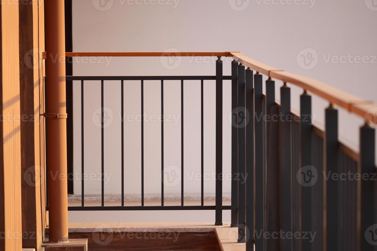 Balcony railing with sunlight shining on a wooden floor photo