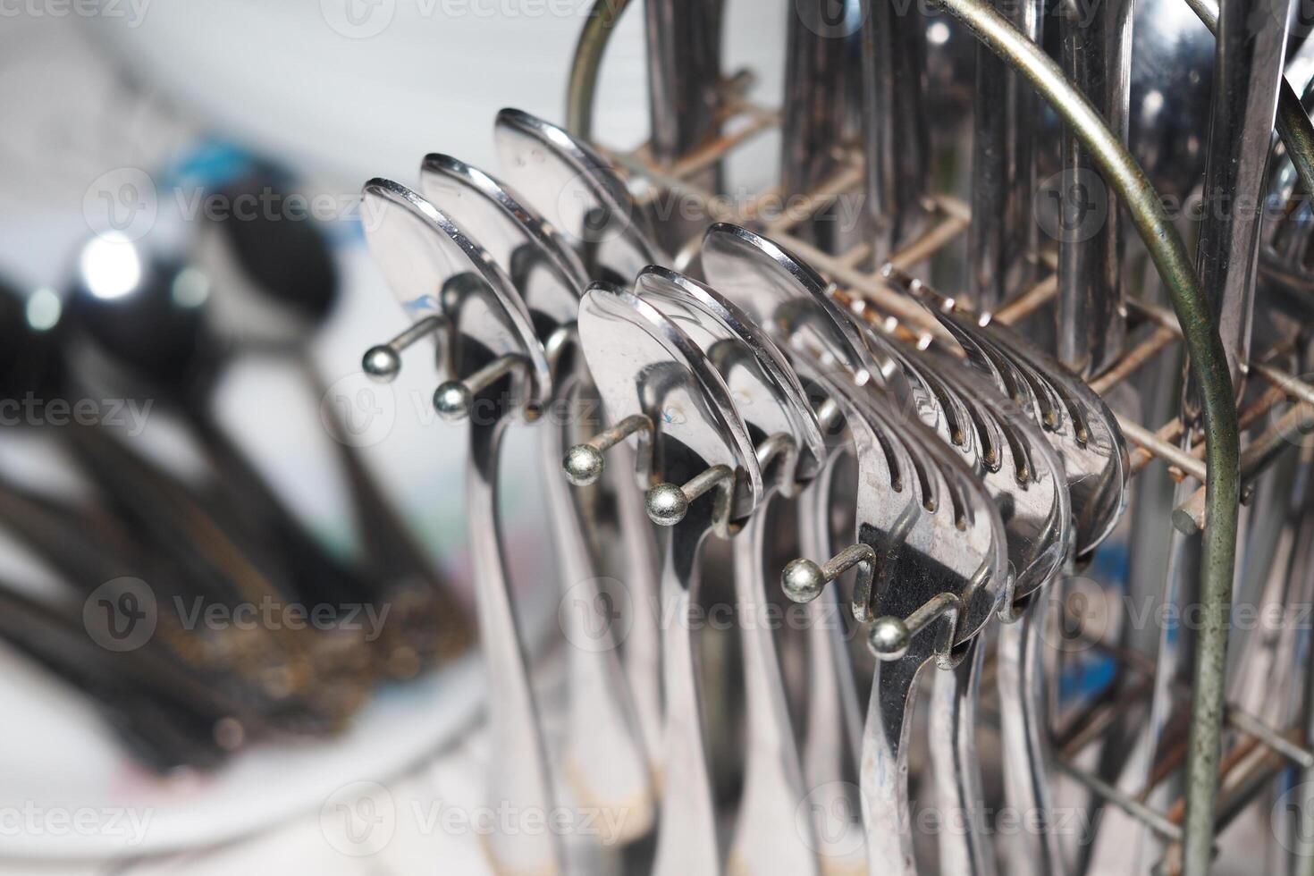 Clean and polished utensils displayed in a kitchen drying rack photo