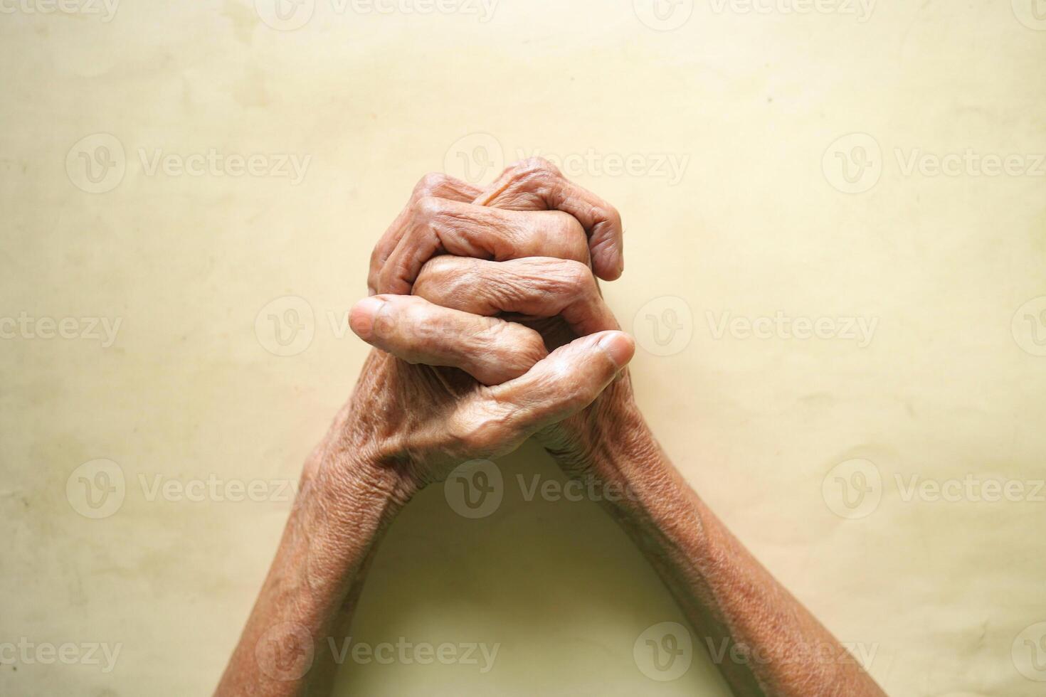 Elderly hands clasped together expressing hope and resilience photo