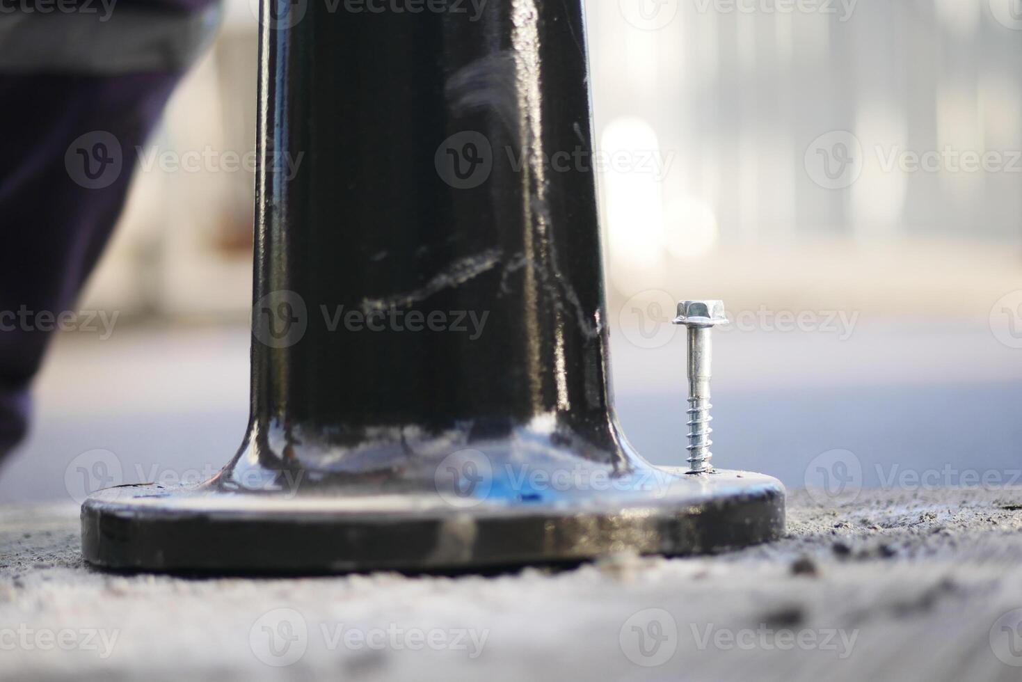 Fixing a pole base on a city street during daylight hours photo