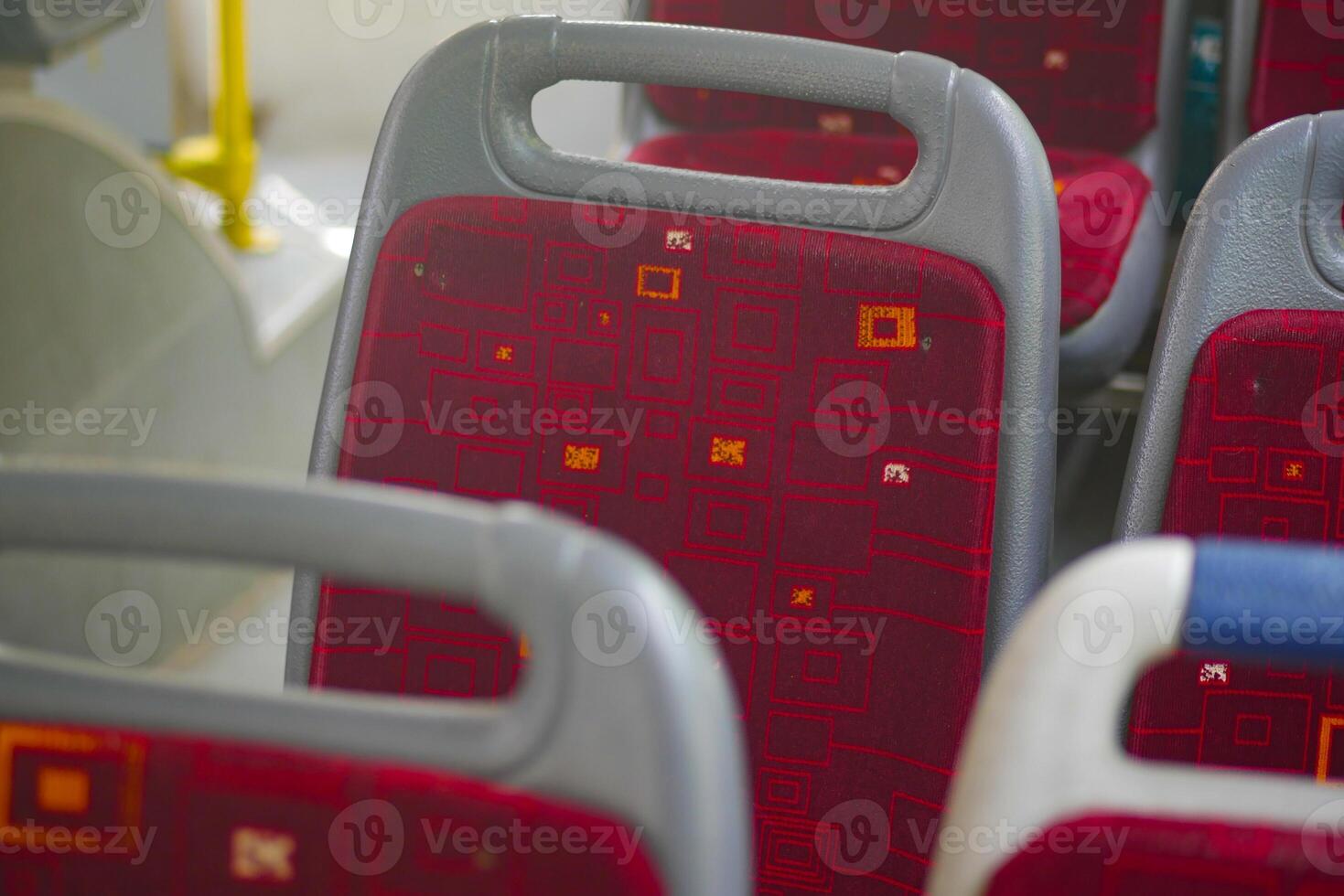 Red upholstered bus seats arranged in a public transport setting photo