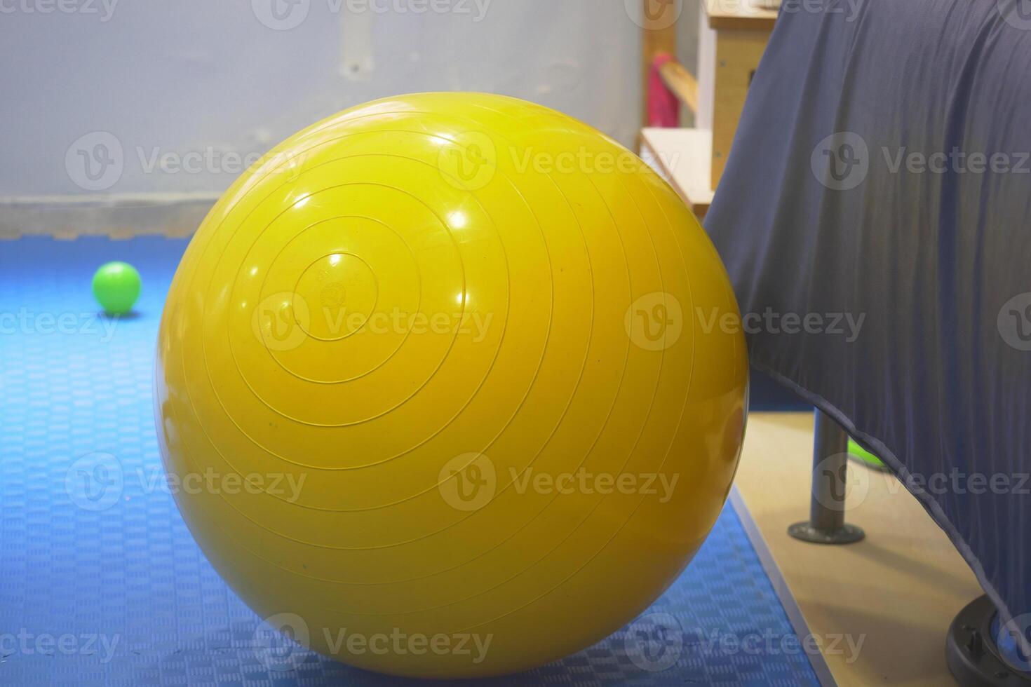 Bright yellow exercise ball placed in a fitness space photo