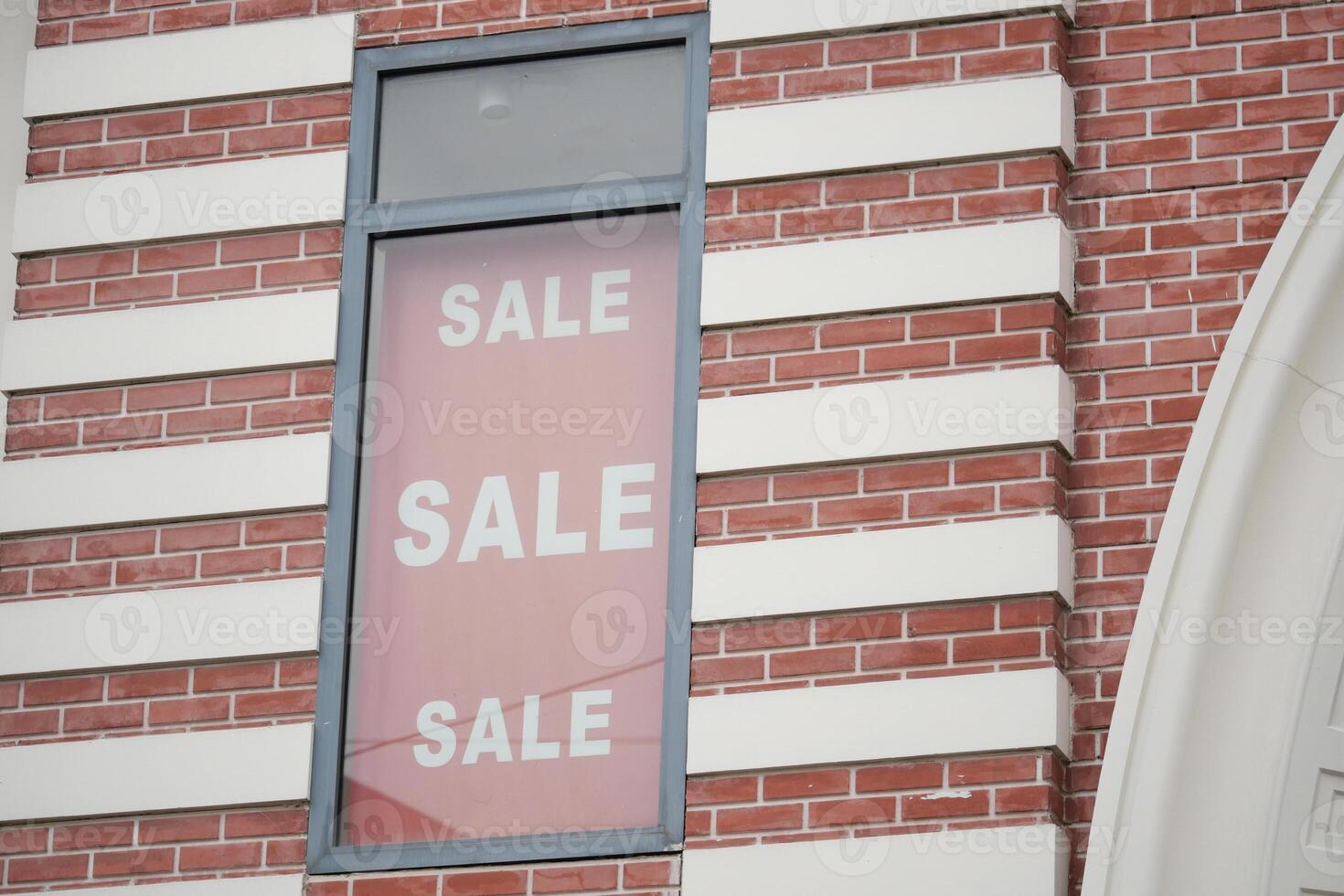 Big sale announcement displayed on brick building window photo