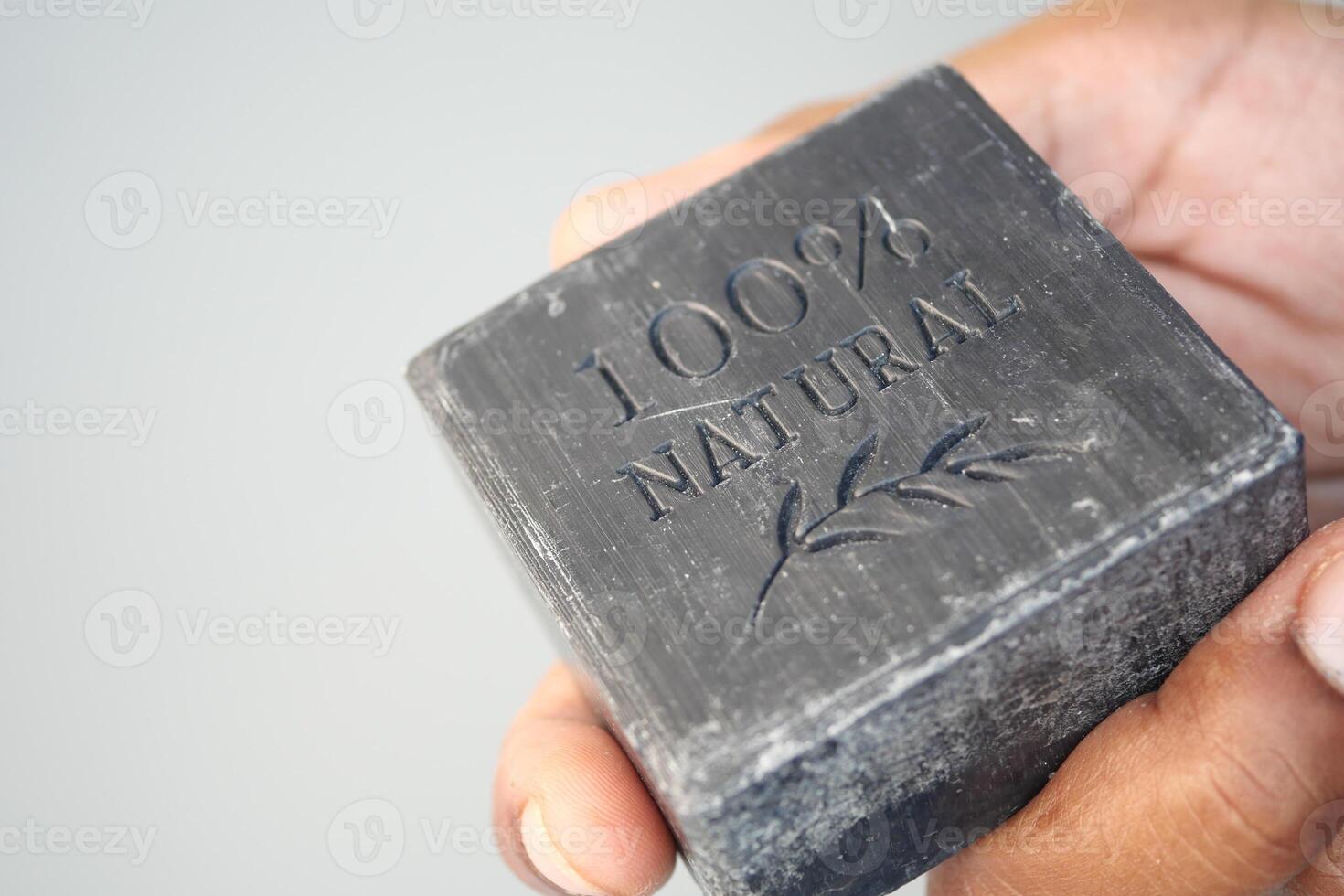 Hand holding a bar of natural soap with engraving details photo
