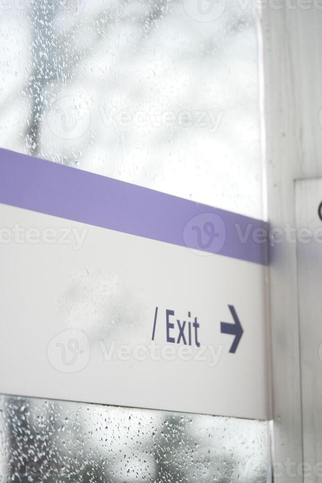 Exit sign with raindrops on glass in a public transport station photo