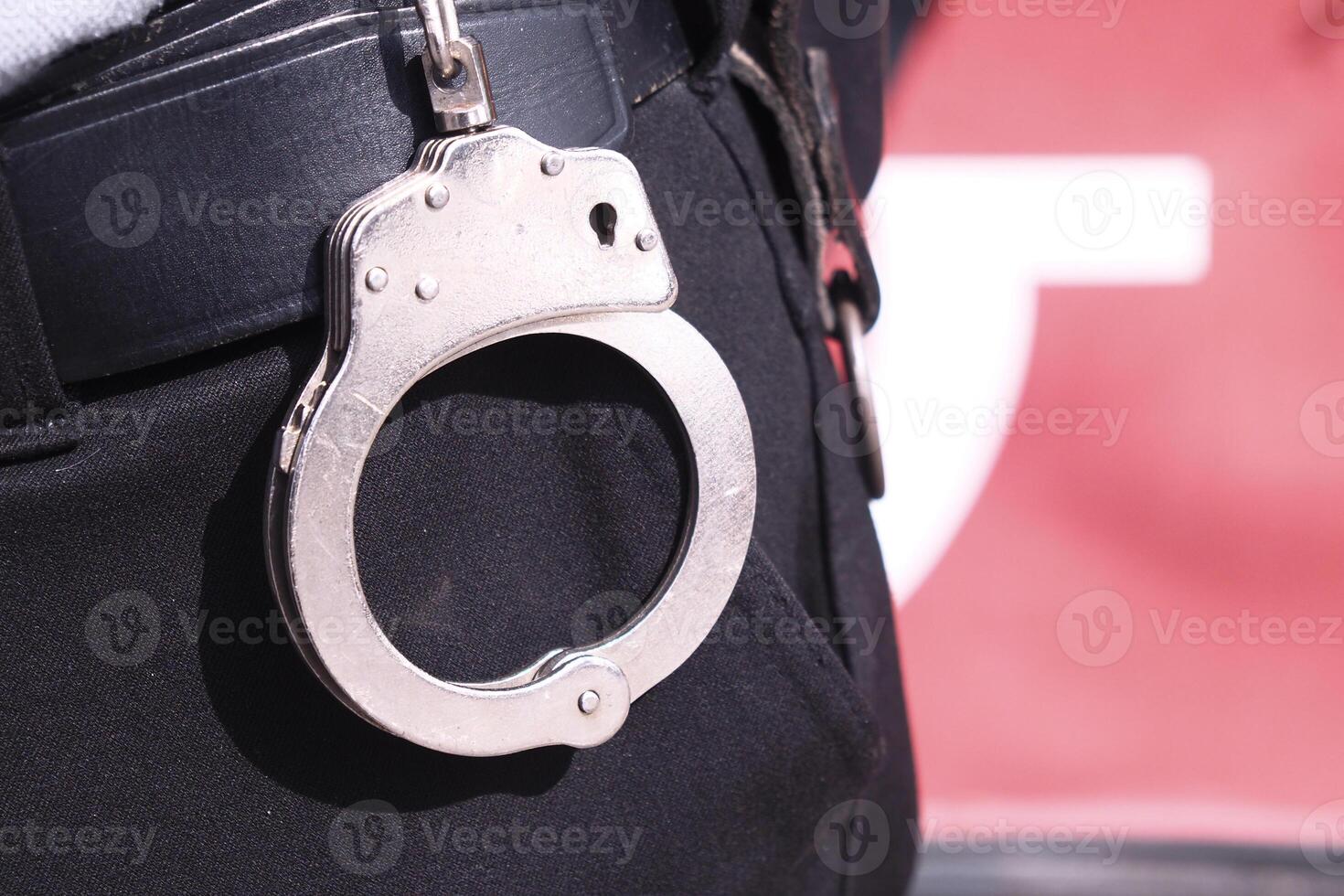 Police officer wearing handcuffs during a law enforcement activity photo