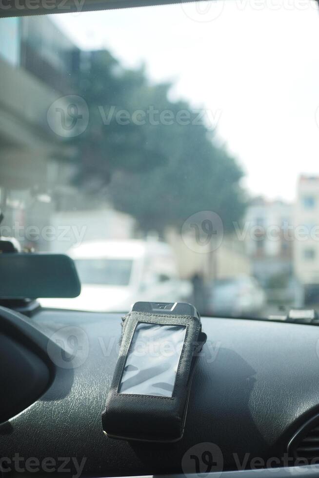 A pos machine rests on a car dashboard, photo
