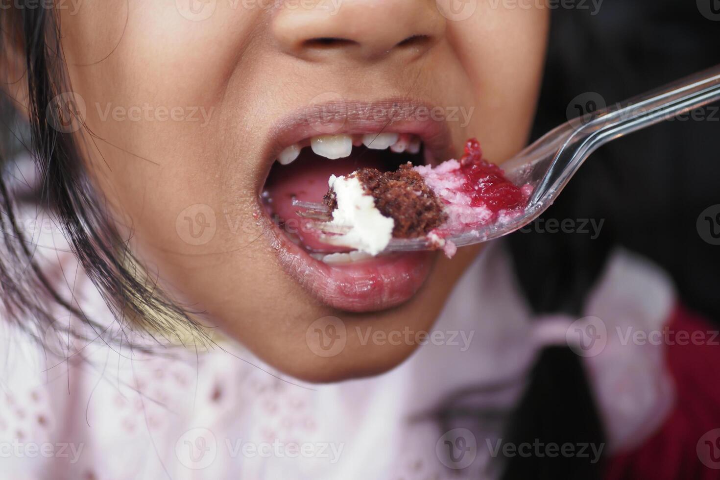 Child enjoying a colorful dessert at a celebration event photo