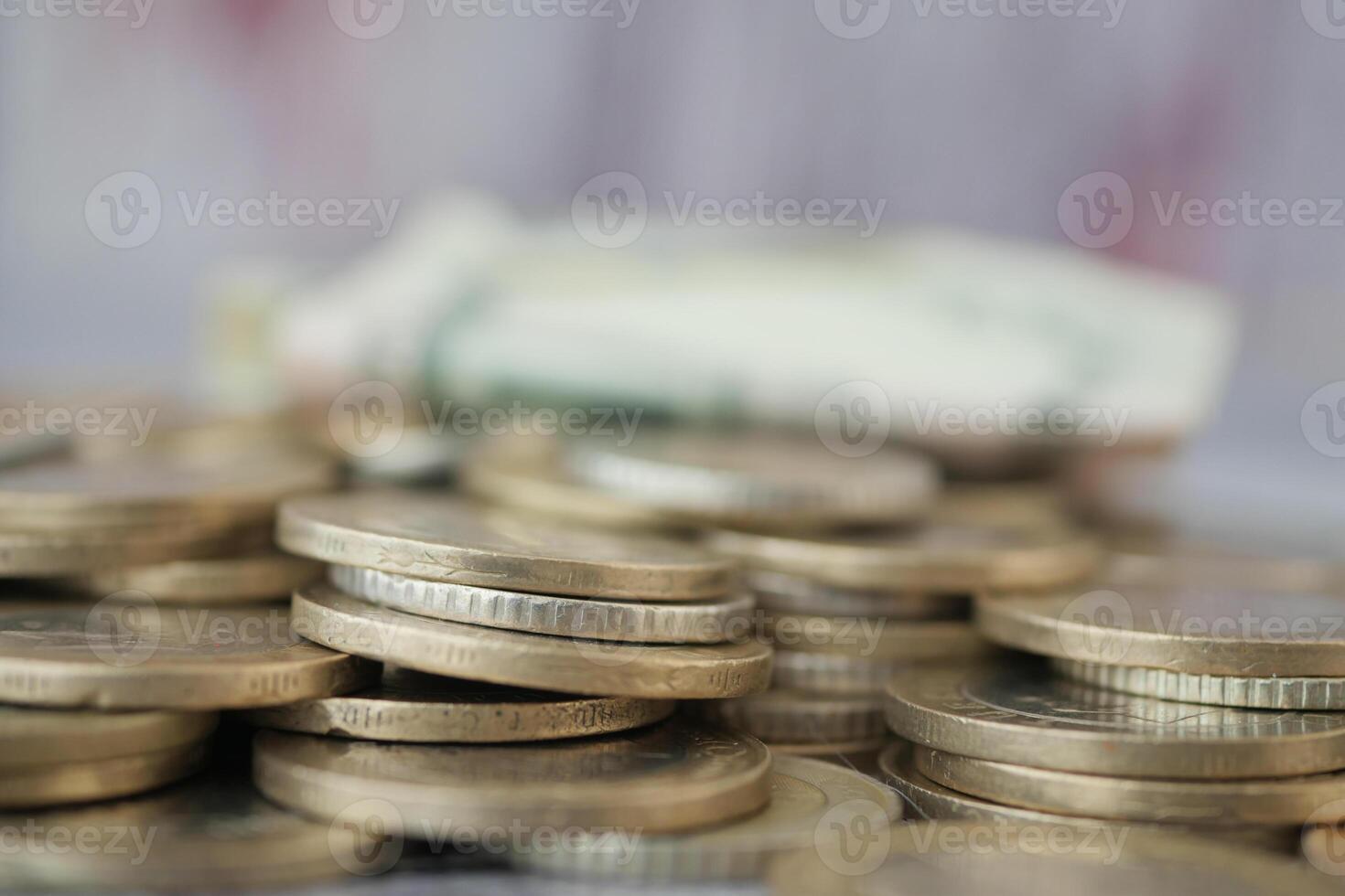 Coins and banknotes arranged on a surface during daylight photo