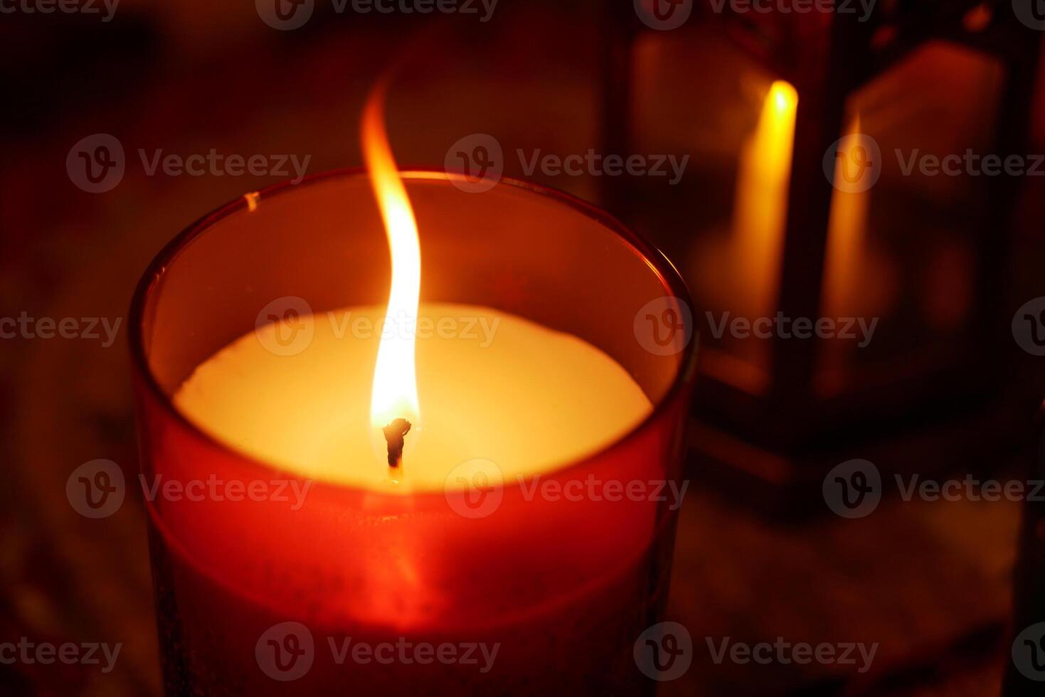 Candle flame glows softly in cozy indoor setting at night photo
