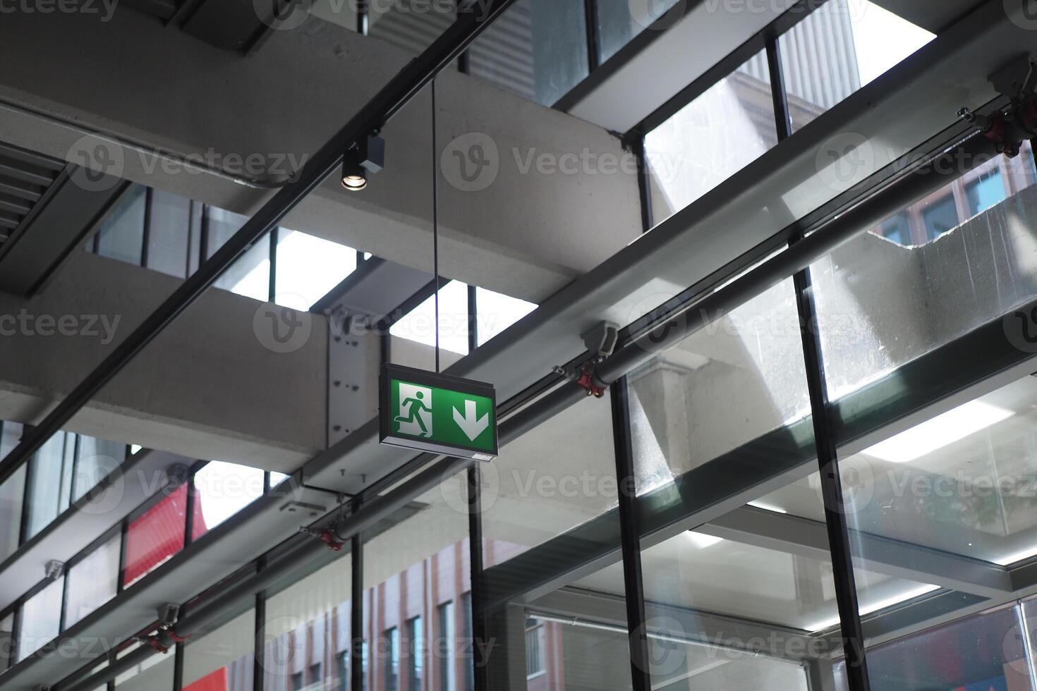 Emergency exit sign illuminated in a modern glass building photo