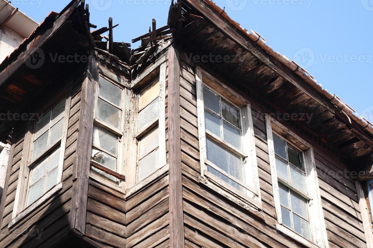 Old wooden structure showing signs of decay in bright sunlight photo