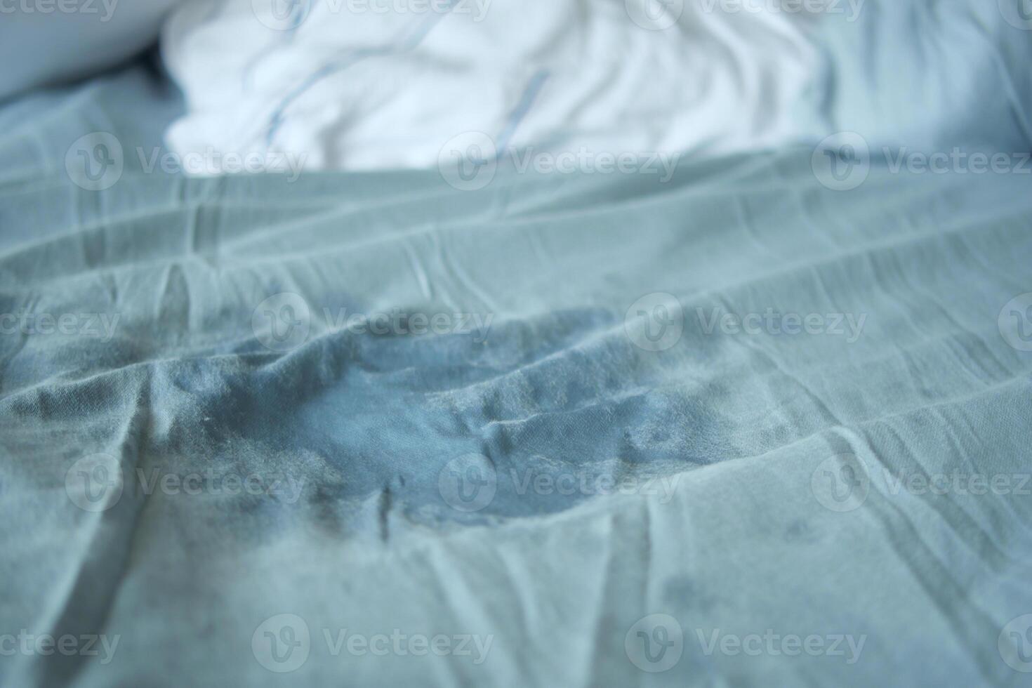 Bed sheet with stain on blue fabric during daytime photo