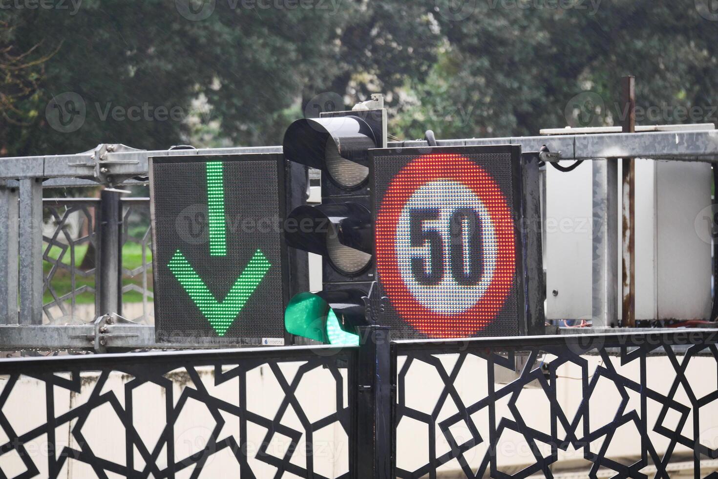 Green arrow signal with speed limit display at a busy intersection photo