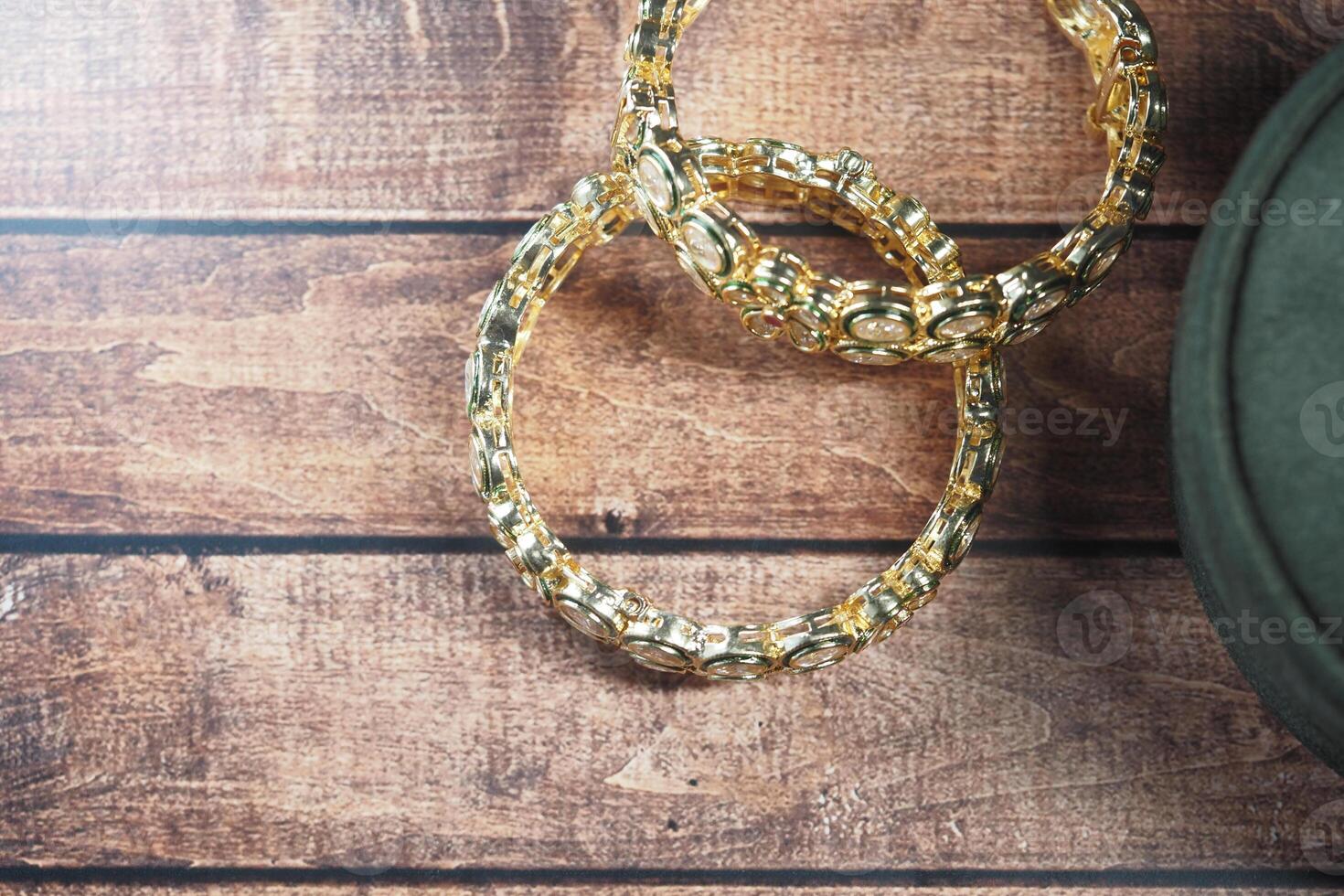 Beautiful gold bangles on a wooden table showcase elegance and style photo