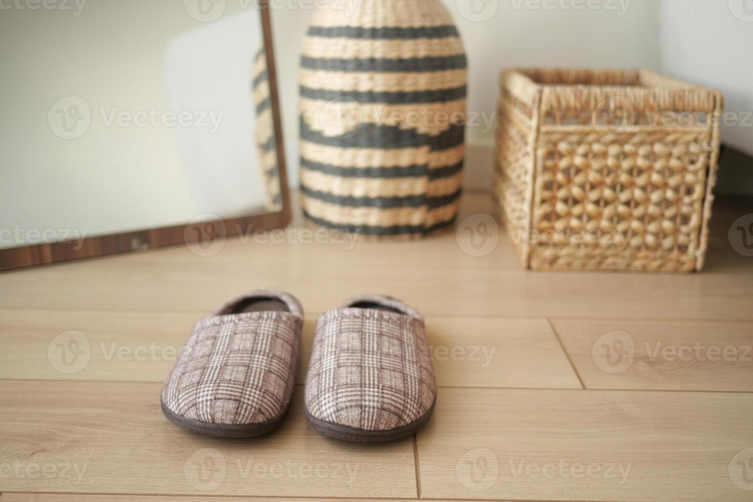 Cozy indoor slippers on wooden floor with decorative baskets photo