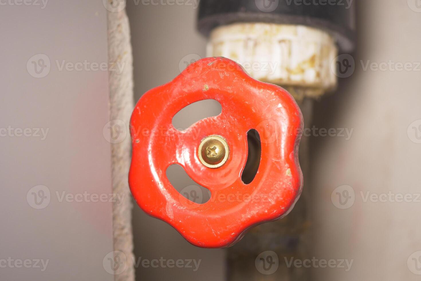 Bright red valve handle on a pipe ready to be turned for maintenance photo