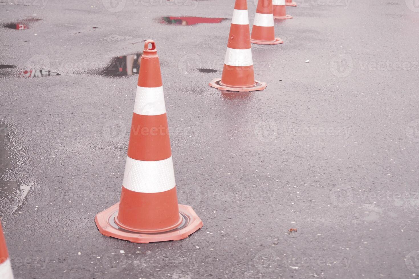 Traffic cones line a wet road after recent rainfall photo
