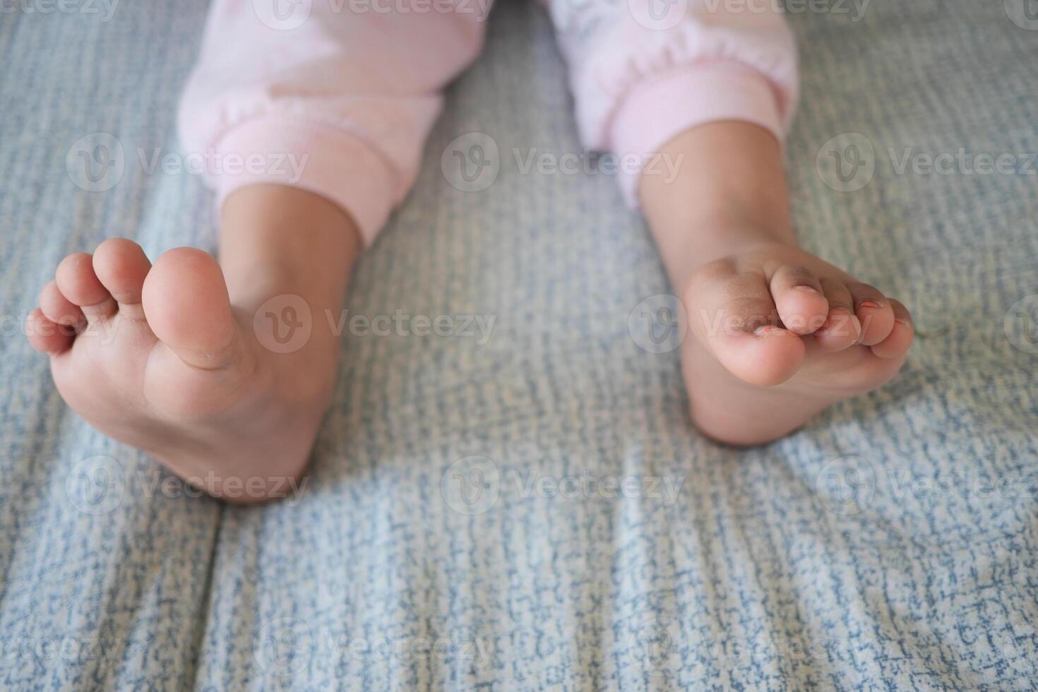 Children playing with bare feet on soft bedding in morning light photo