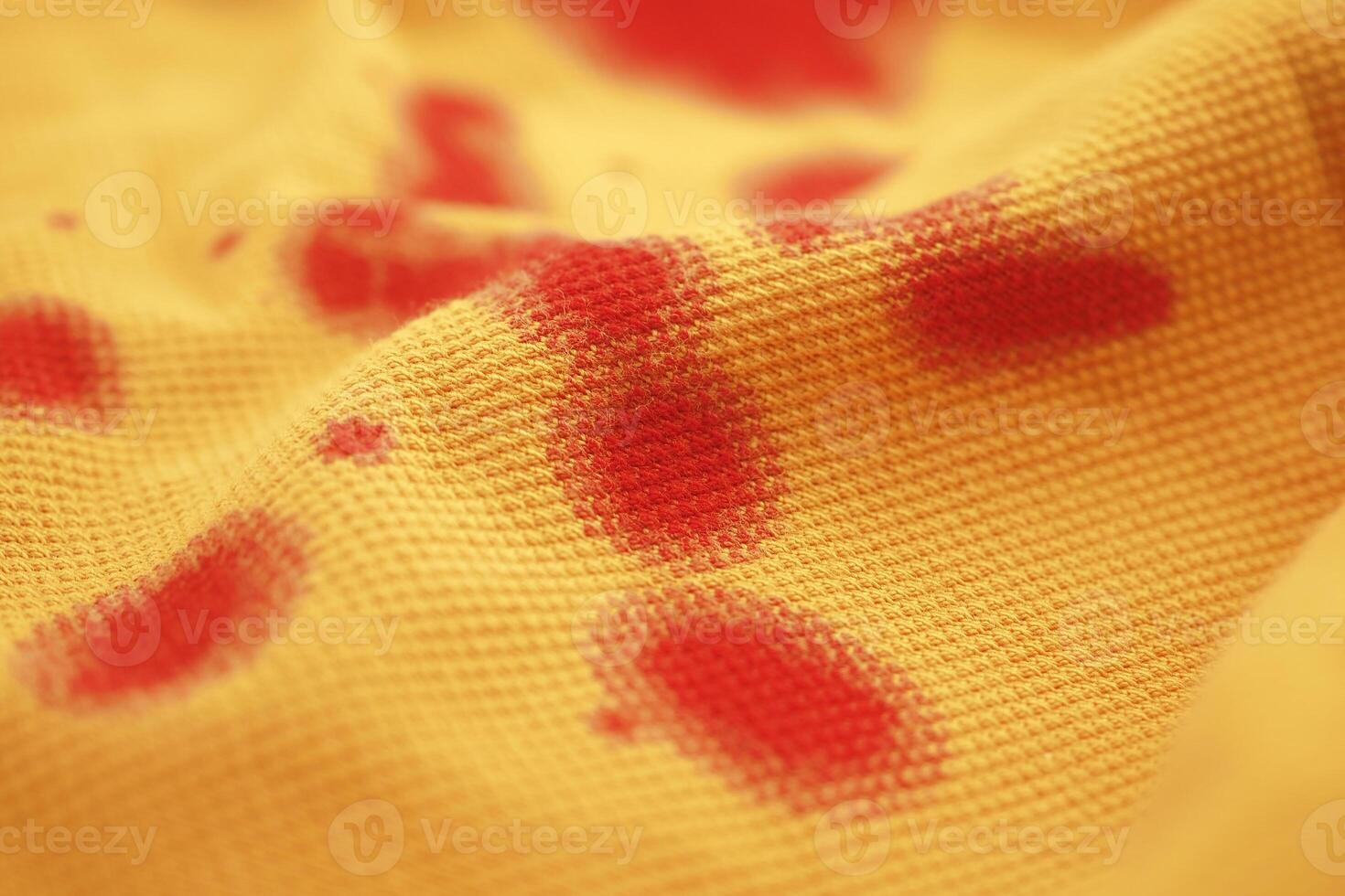 Fabric with vibrant red spots on a textured yellow background photo