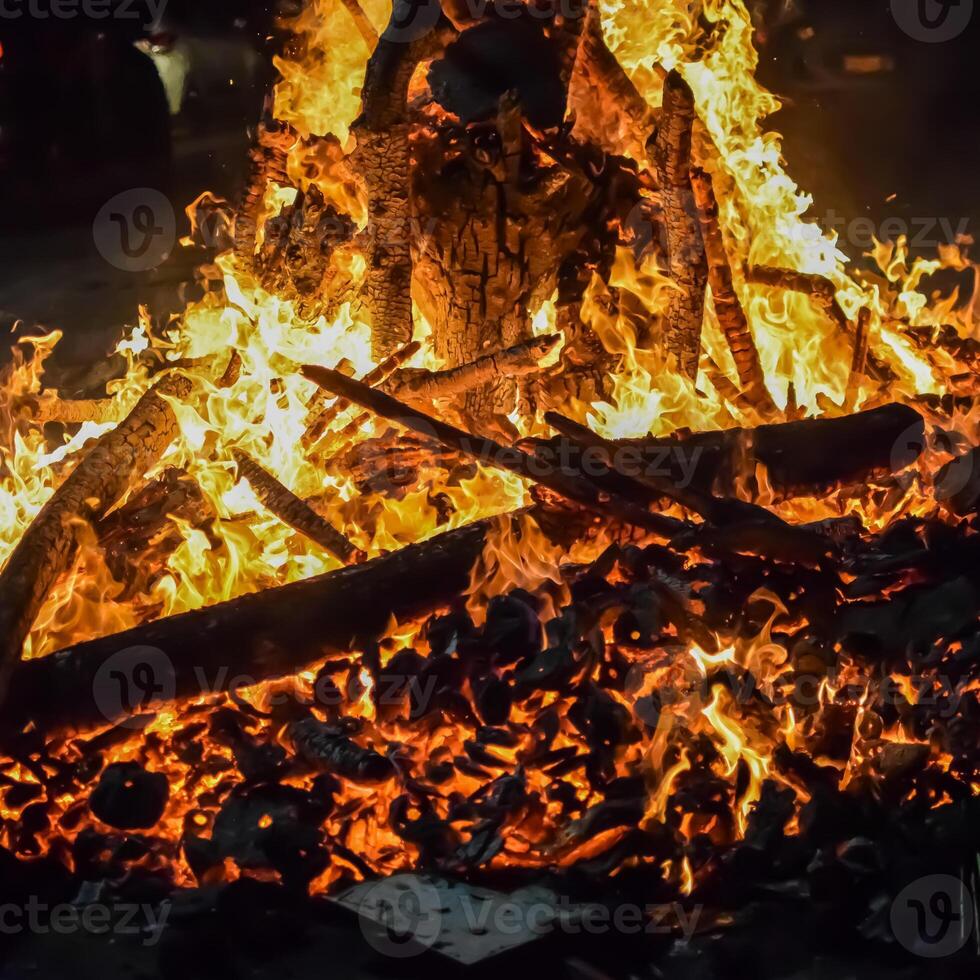 A bonfire is lit up in the middle of the night photo