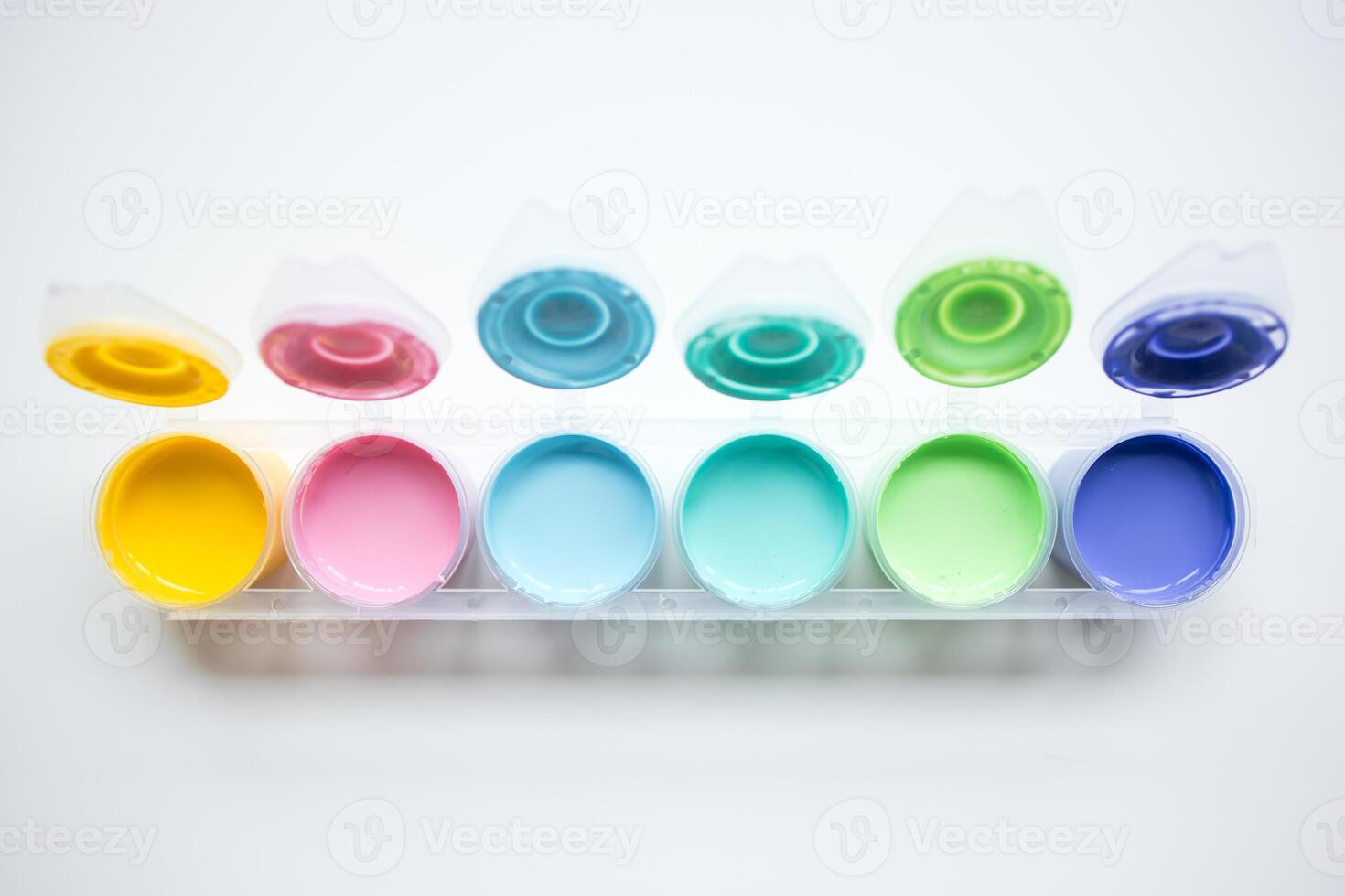 Colorful paint set with open lids displaying vibrant hues photo
