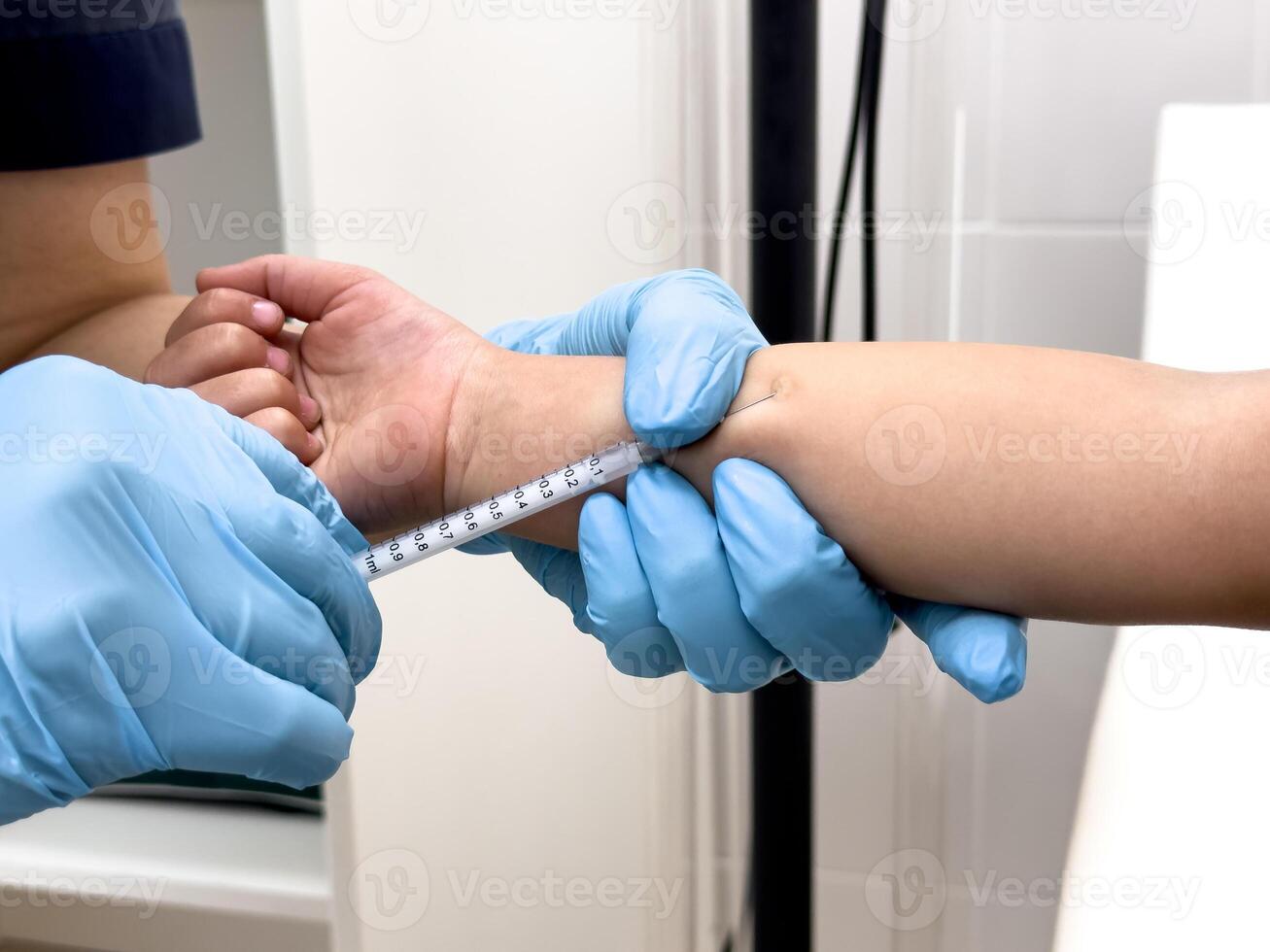 Healthcare worker administering vaccine to asian child with blue gloves in clinic photo