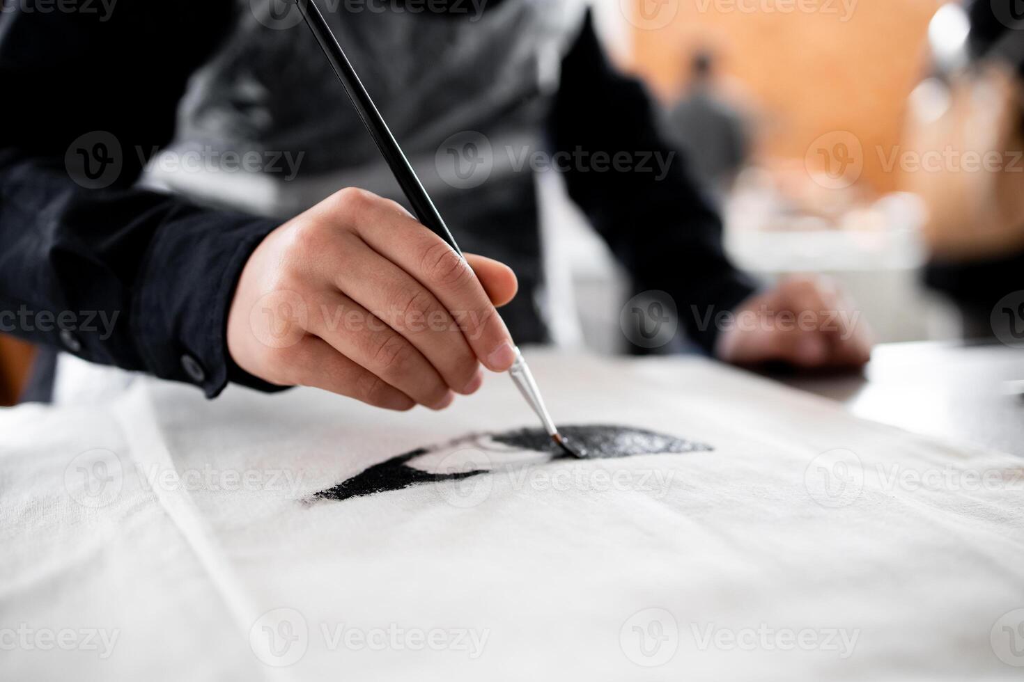 Asian adult engaged in painting artistic project with precision and skill photo