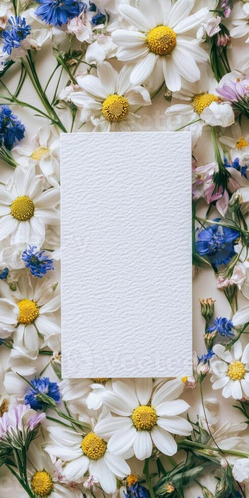 Botanical flat lay design with blank white invitation surrounded by colorful flowers for event stationery photo