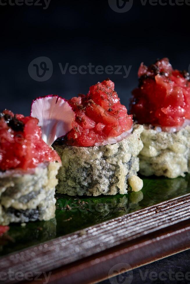 Sushi rolls with red sauce on a green plate photo
