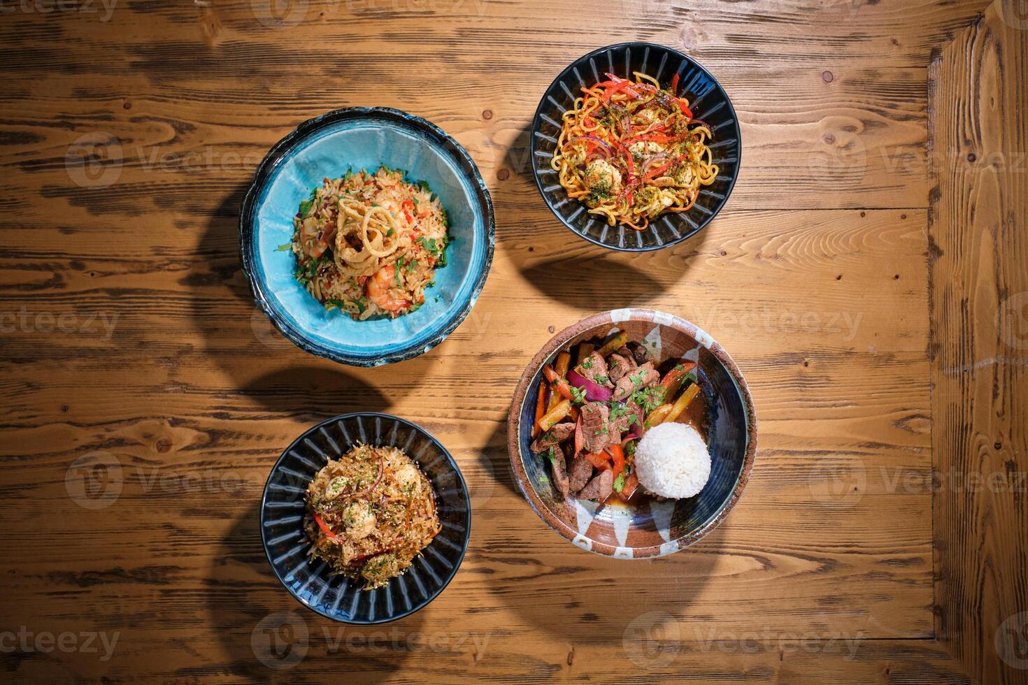 Four bowls of food on a wooden table photo