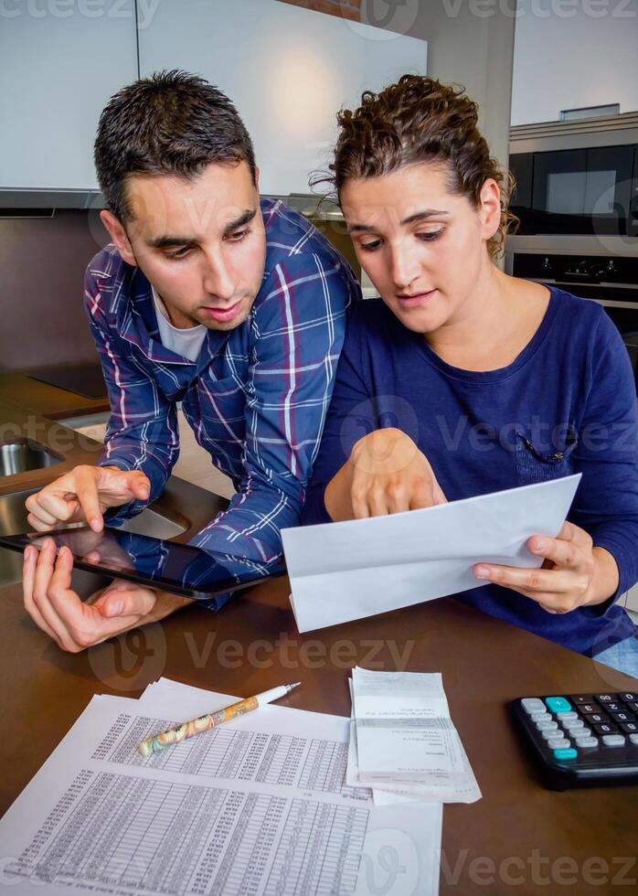A man and woman looking at paperwork while sitting at a table photo