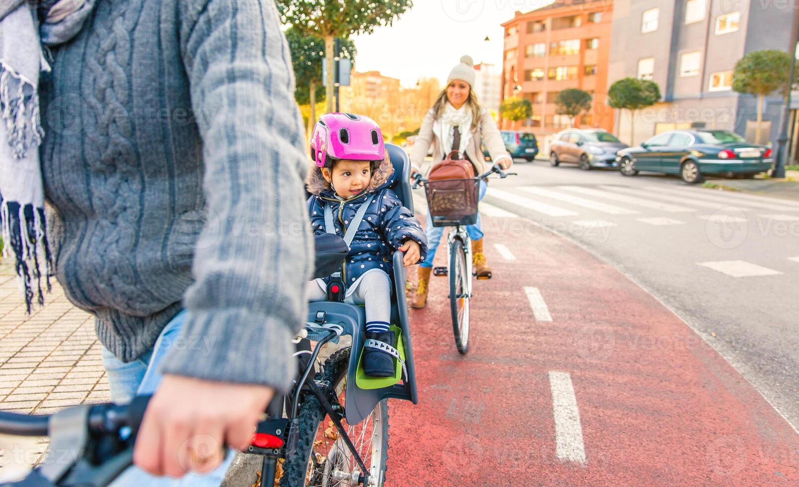 A family riding bicycles on a city street photo