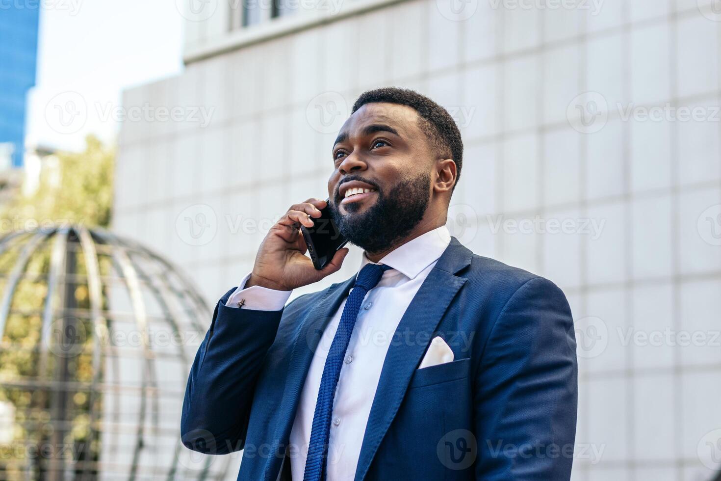 A man in a suit and tie talking on his cell phone while looking away photo