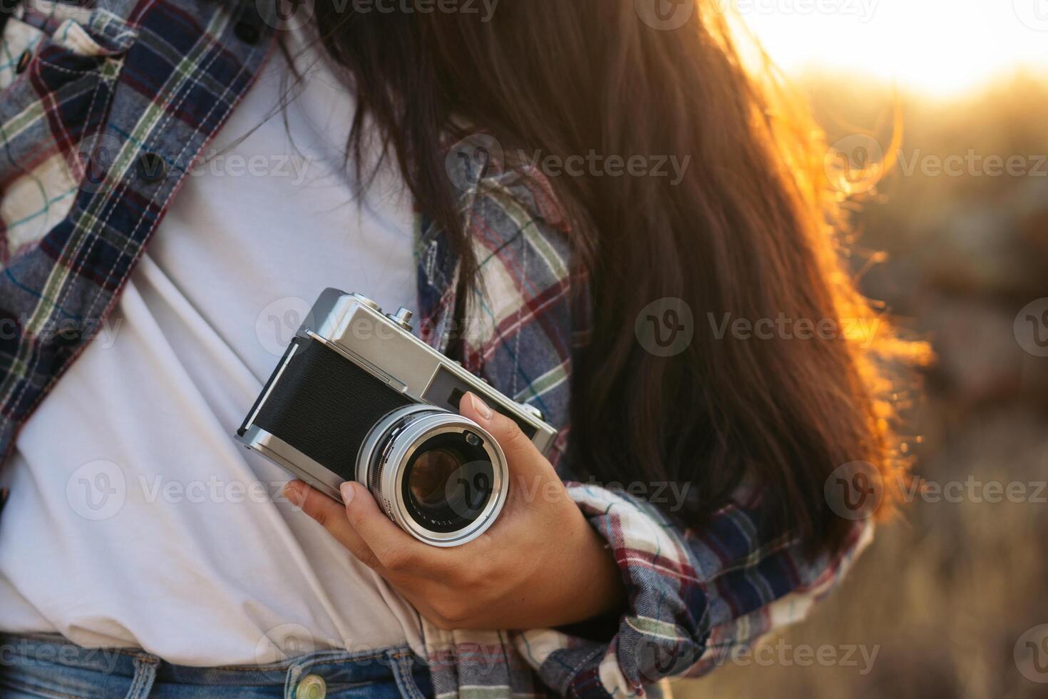 A woman holding a camera in the field photo