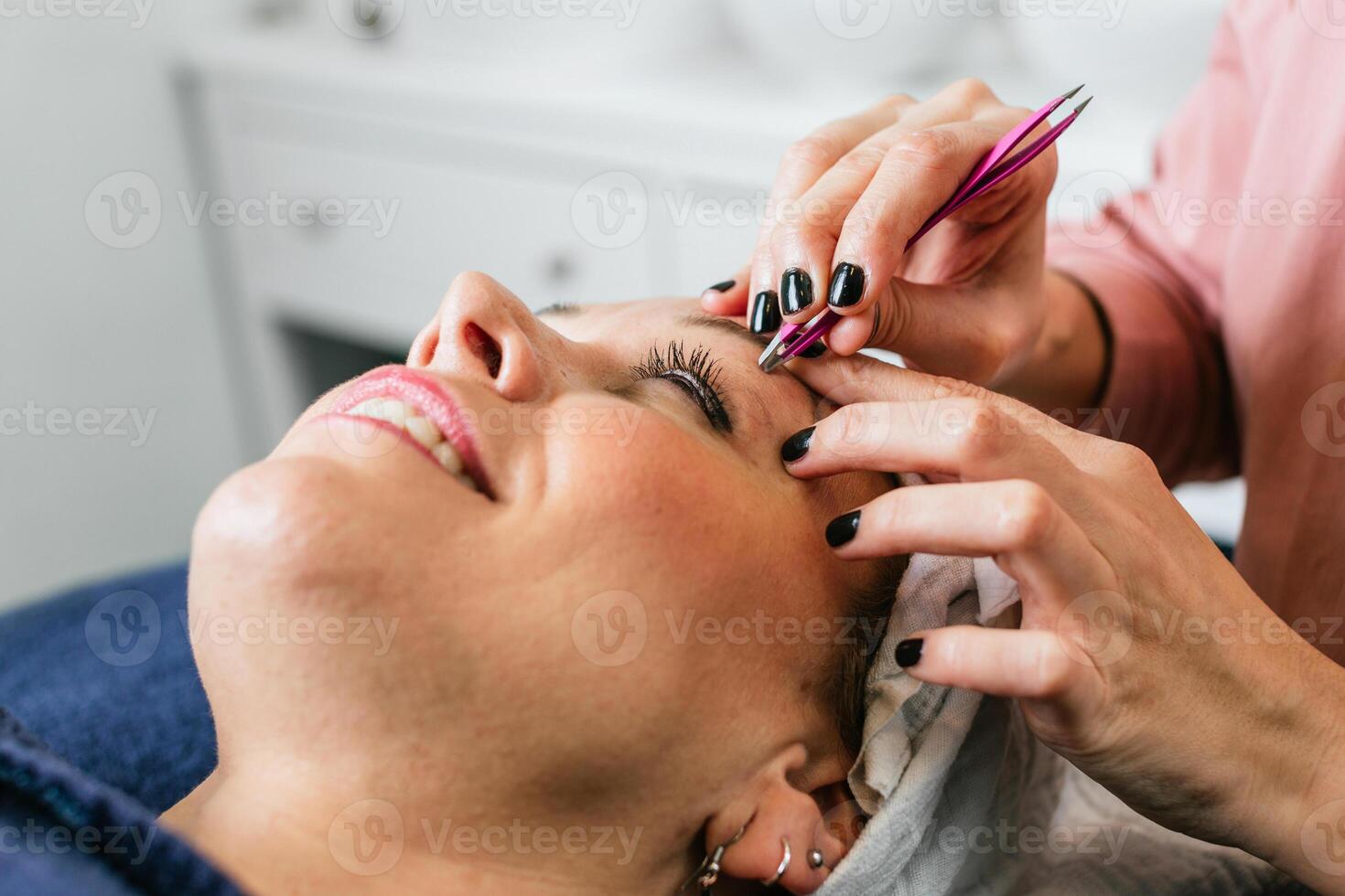 A woman getting her eyebrows done at a beauty salon photo