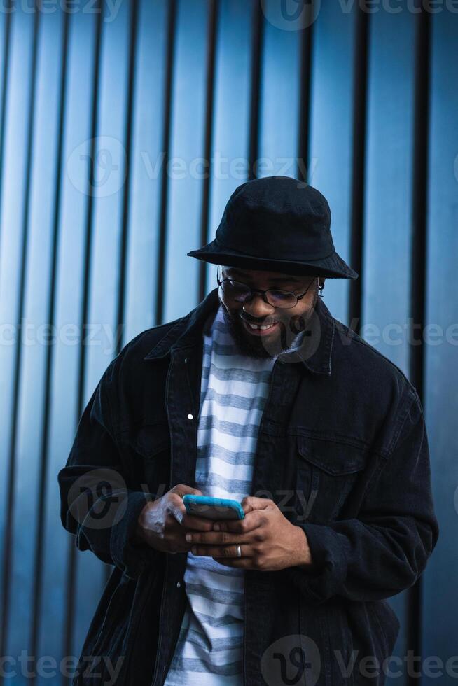 A man in a hat and jacket is looking at his phone photo
