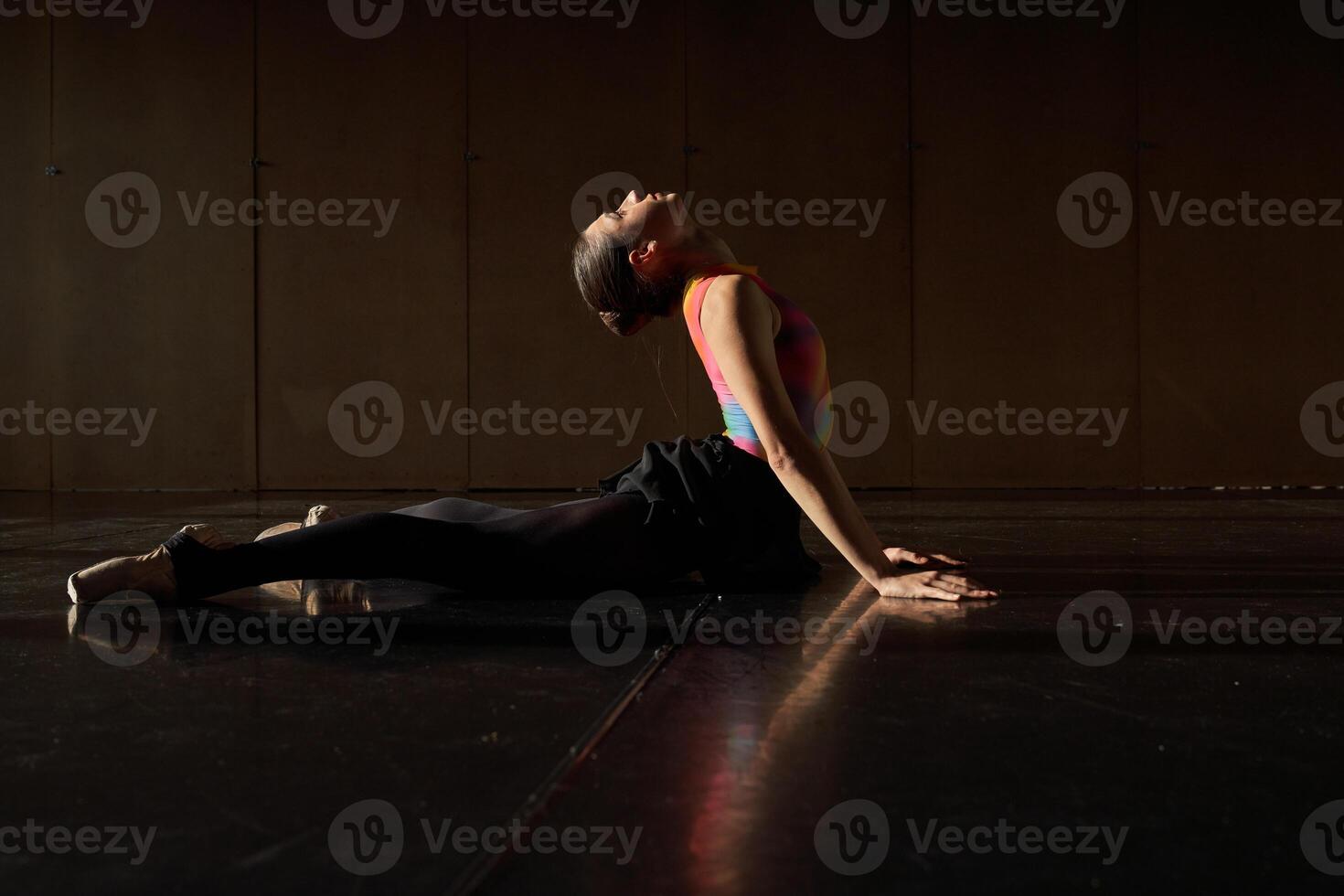 A woman in a colorful outfit is sitting on the floor photo