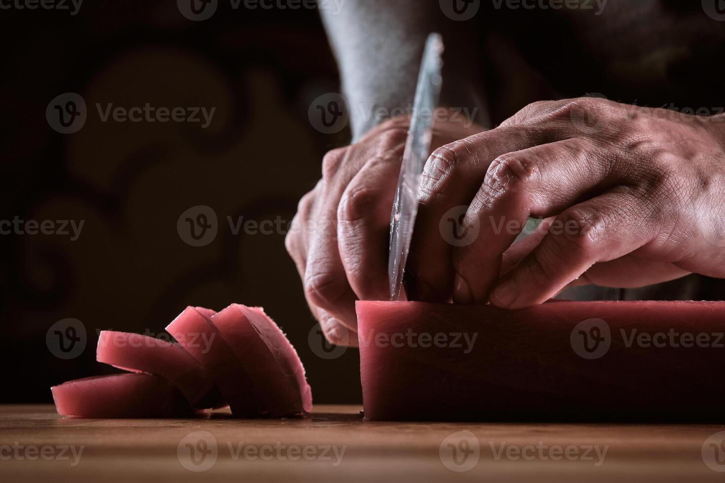 A person cutting up a piece of meat with a knife photo