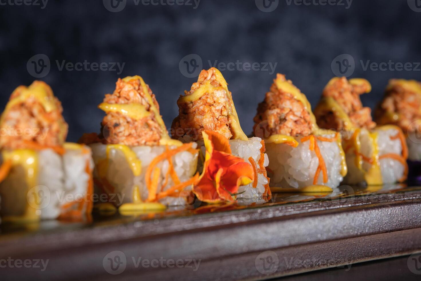 A tray of sushi with sauce and cheese. photo