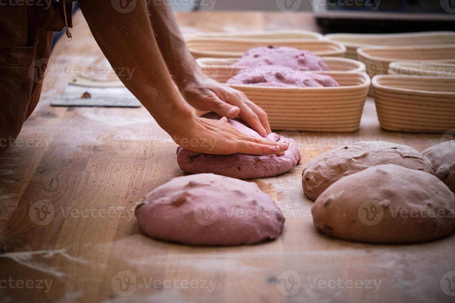 A chef is kneading dough on a table photo