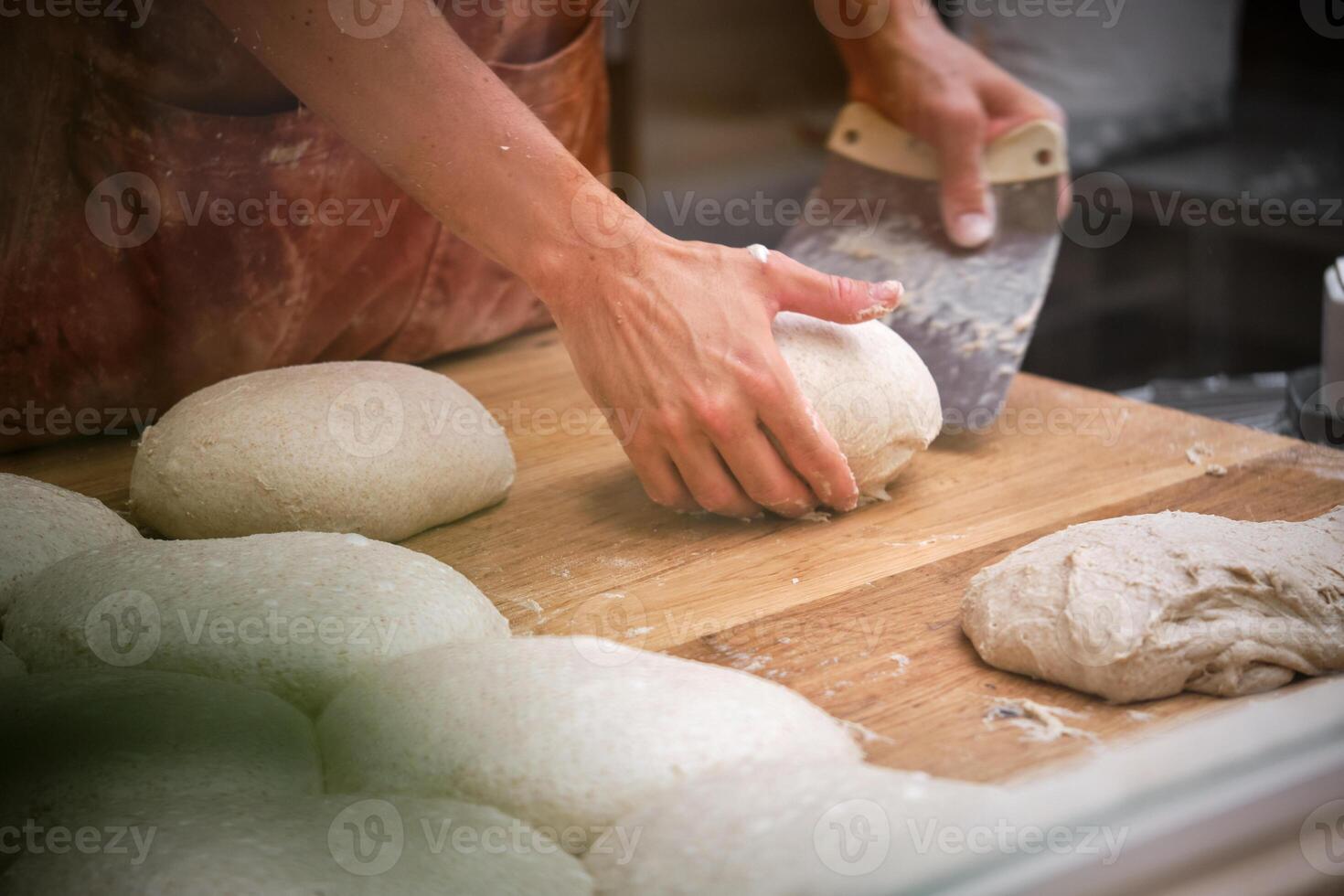 A person is kneading dough on a table. photo