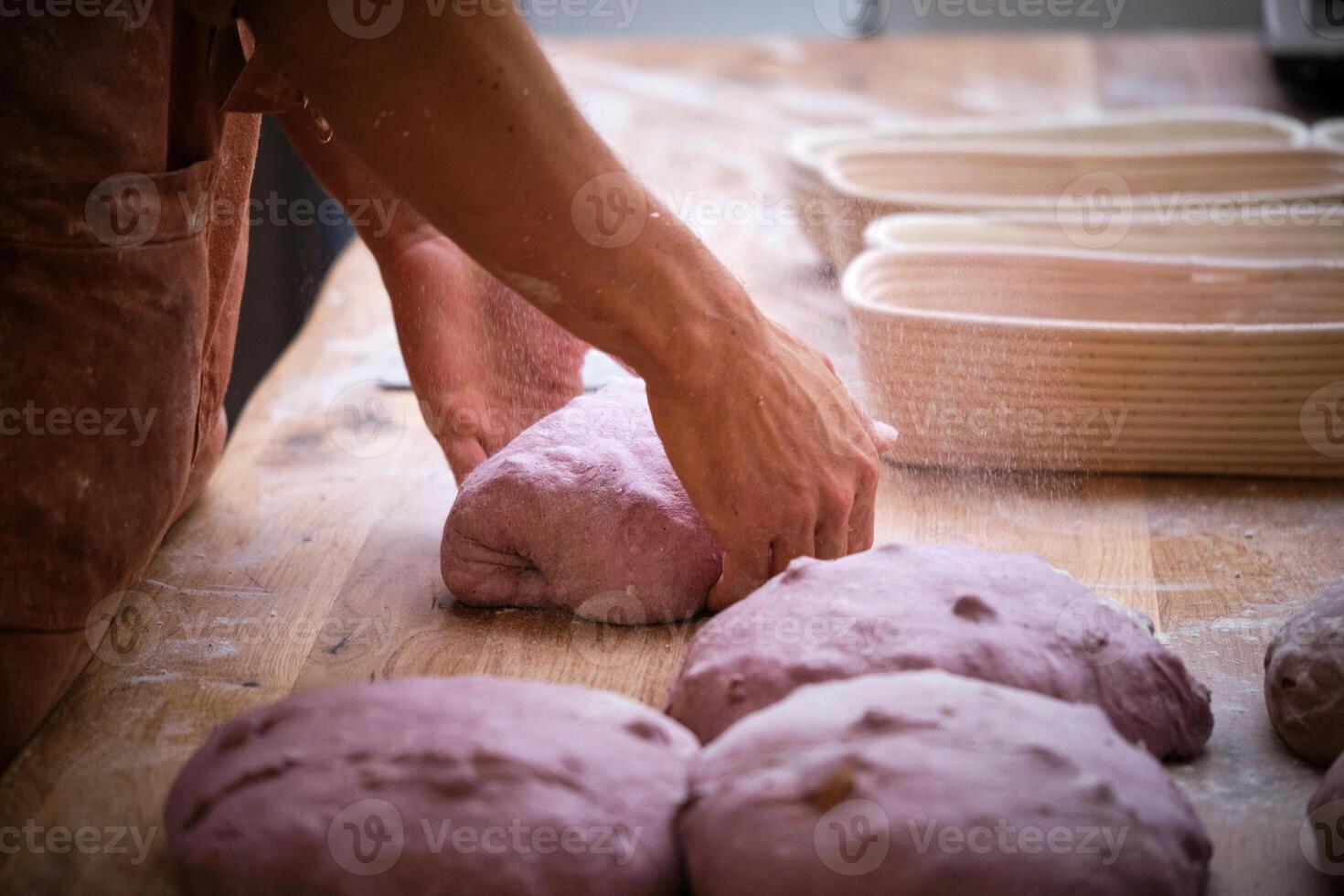 A chef is kneading dough on a table. photo