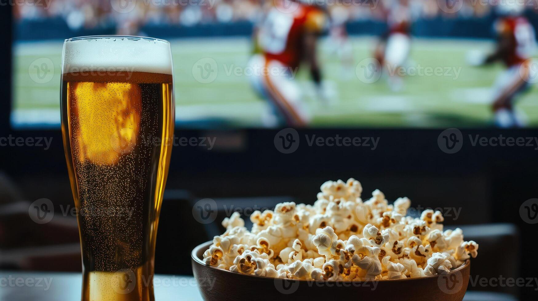 A refreshing beer and bowl of popcorn for game day enjoyment. photo