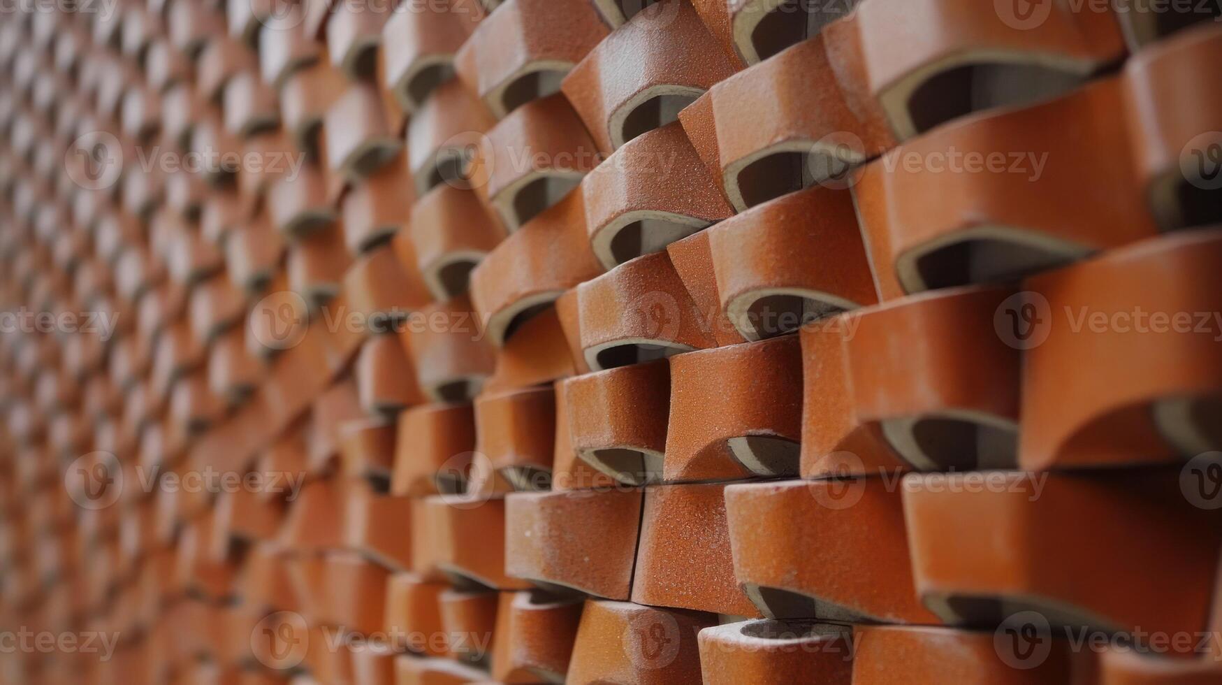 A textured, warm toned wall of stacked clay bricks showcasing craftsmanship. photo