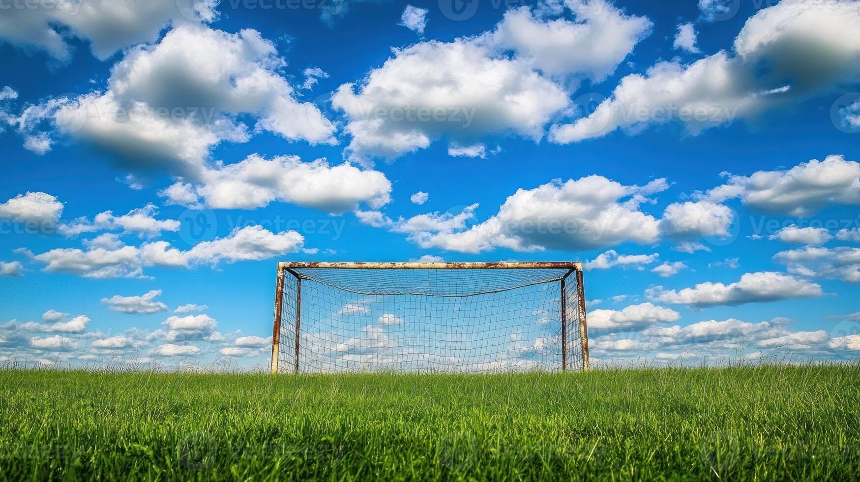 A serene soccer goal set against a vivid blue sky and lush grass. photo