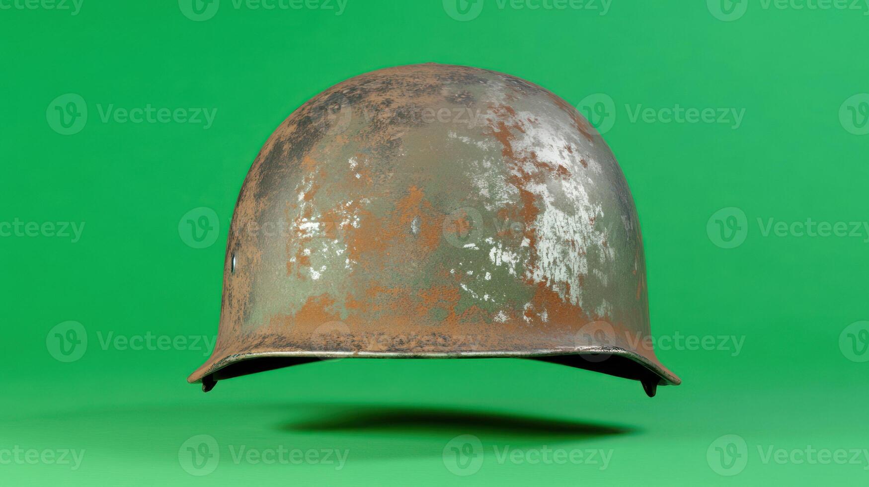 A vintage military helmet with a rustic finish against a green background. photo