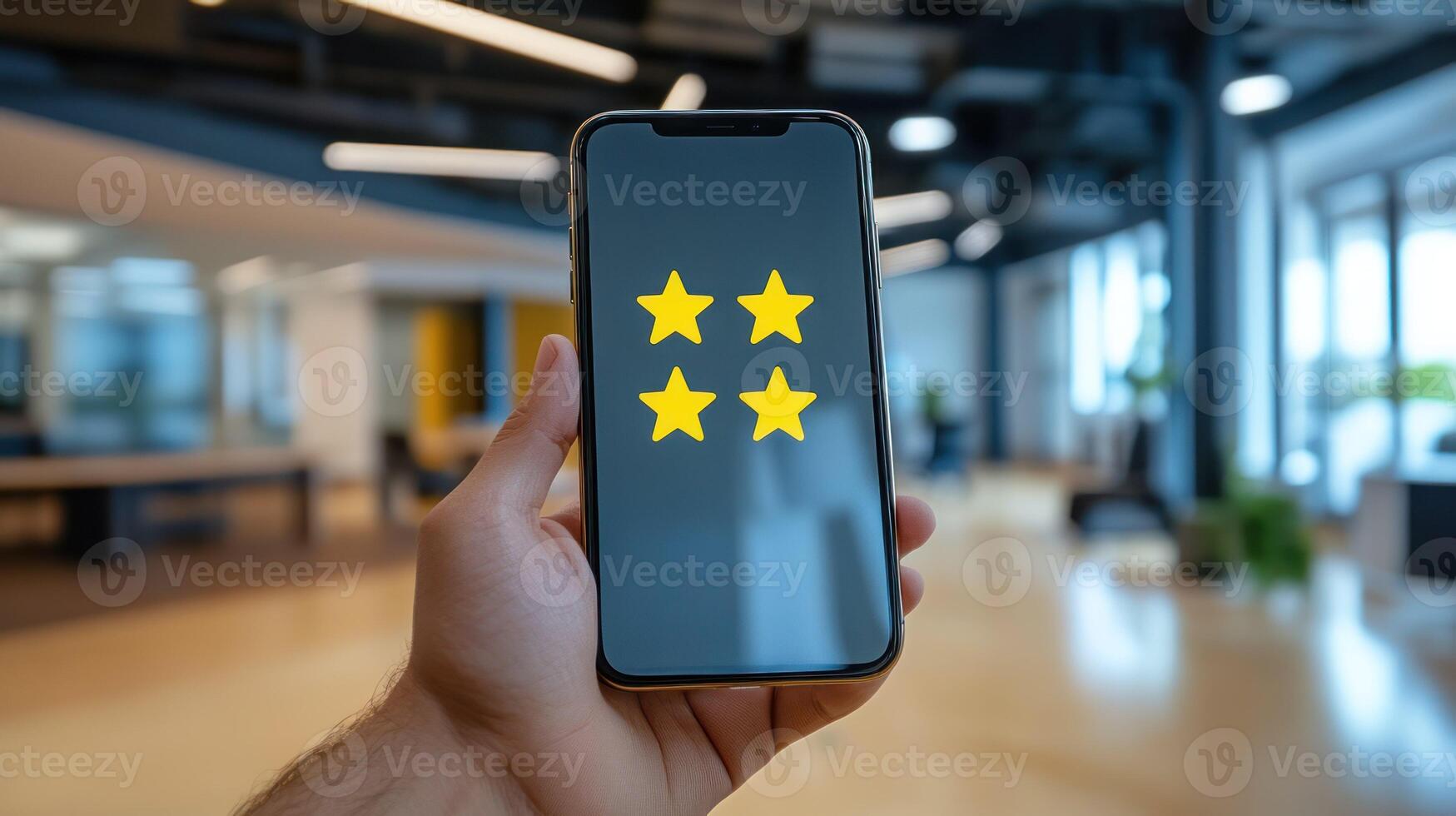 A hand holding a smartphone displaying a three star rating in an office. photo