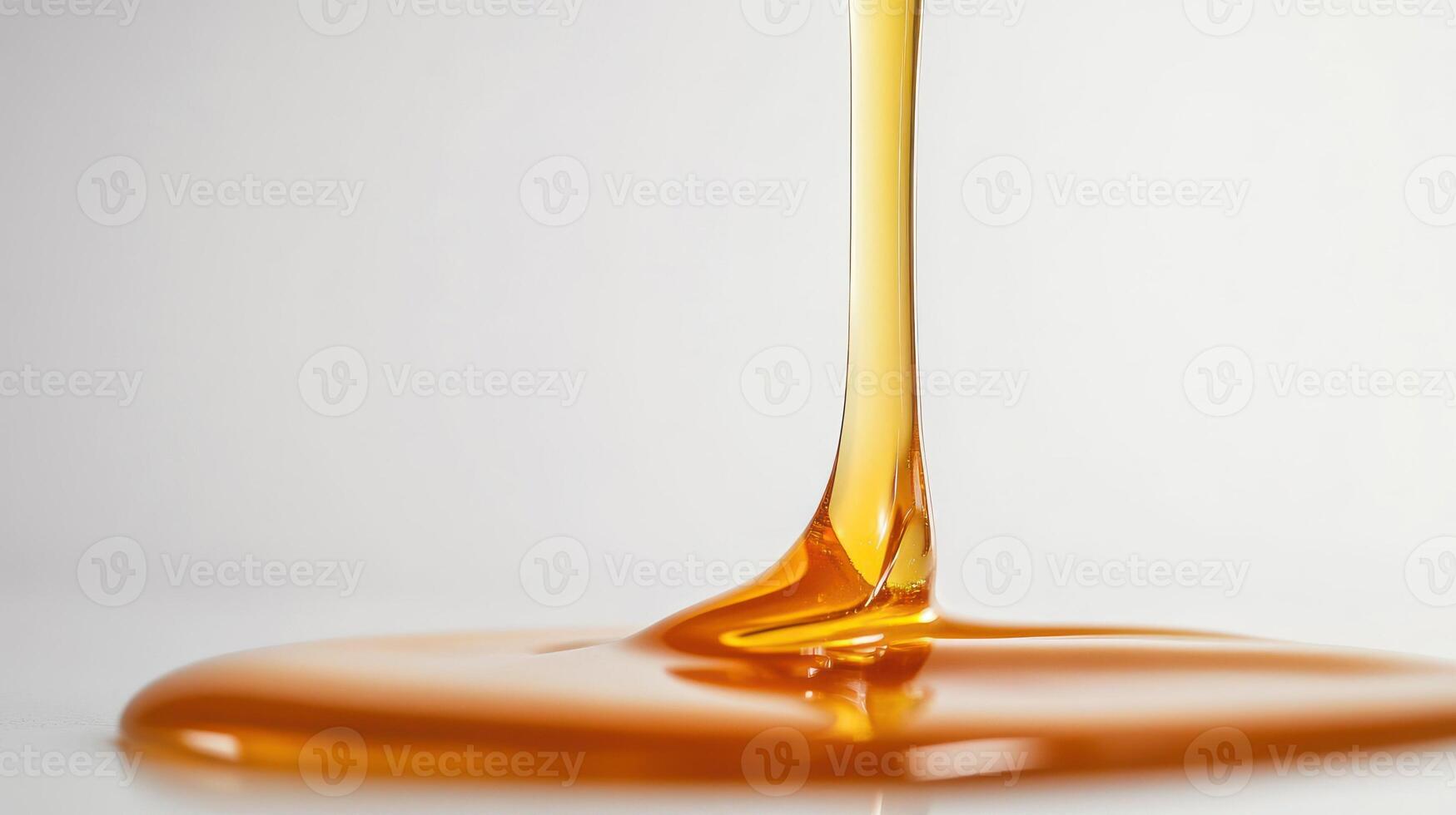 Close up of golden syrup dripping in a smooth, glossy flow. photo