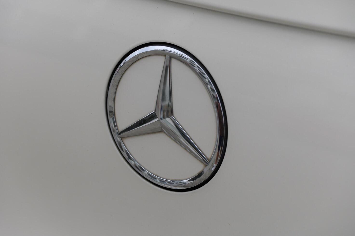 Gaziveren Cyprus -17.03.2025 Mercedes-AMG Shining emblem displayed on classic car parked under evening sun in quiet suburban neighborhood photo